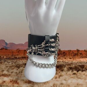 Black faux leather cuff with silver skull skeleton hand hardware